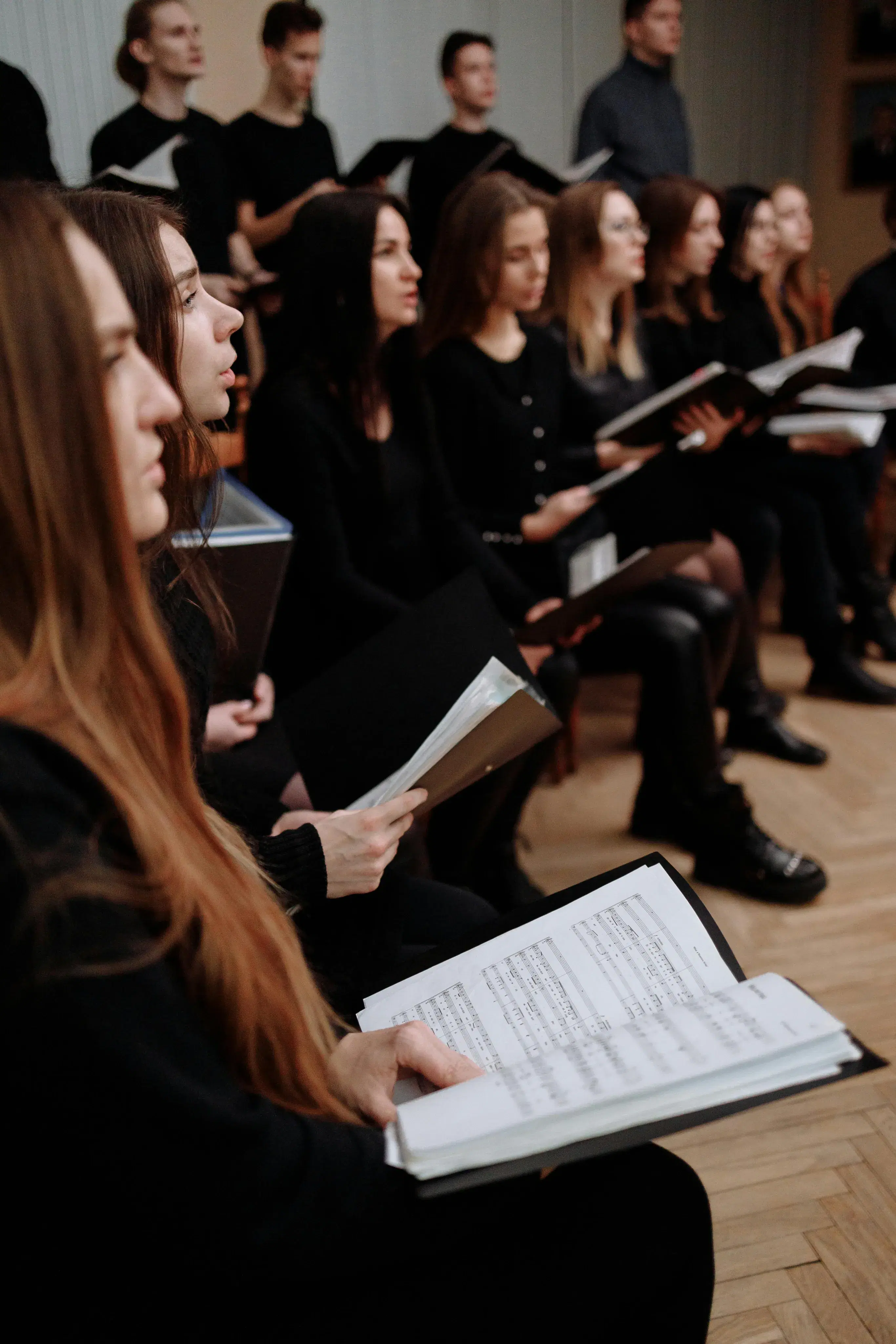 Choir singers performing in harmony with SATB vocal sections and choir director